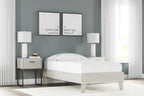 Platform bed with light wood frame and white mattress, smooth panels and slatted base