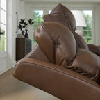 Brown power reclining sofa back and arm detail with stitched leather-like upholstery