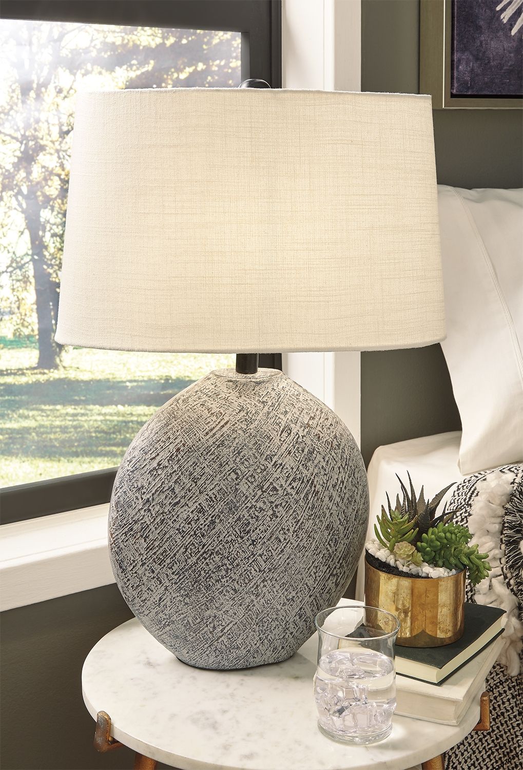 Beige paper table lamp with gray fabric globe base on small round table