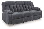 Reclining power sofa, dark gray tufted fabric, padded arms and reclined seat