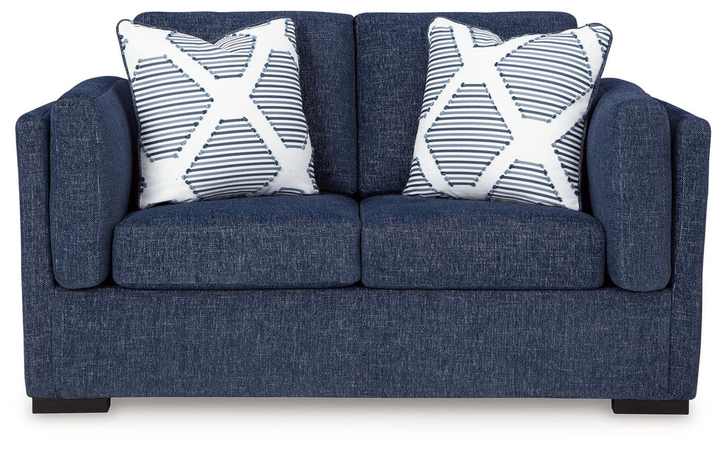 Blue loveseat sofa with two white-and-blue striped throw pillows
