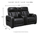 Black power reclining loveseat with console, quilted upholstery, and adjustable headrests