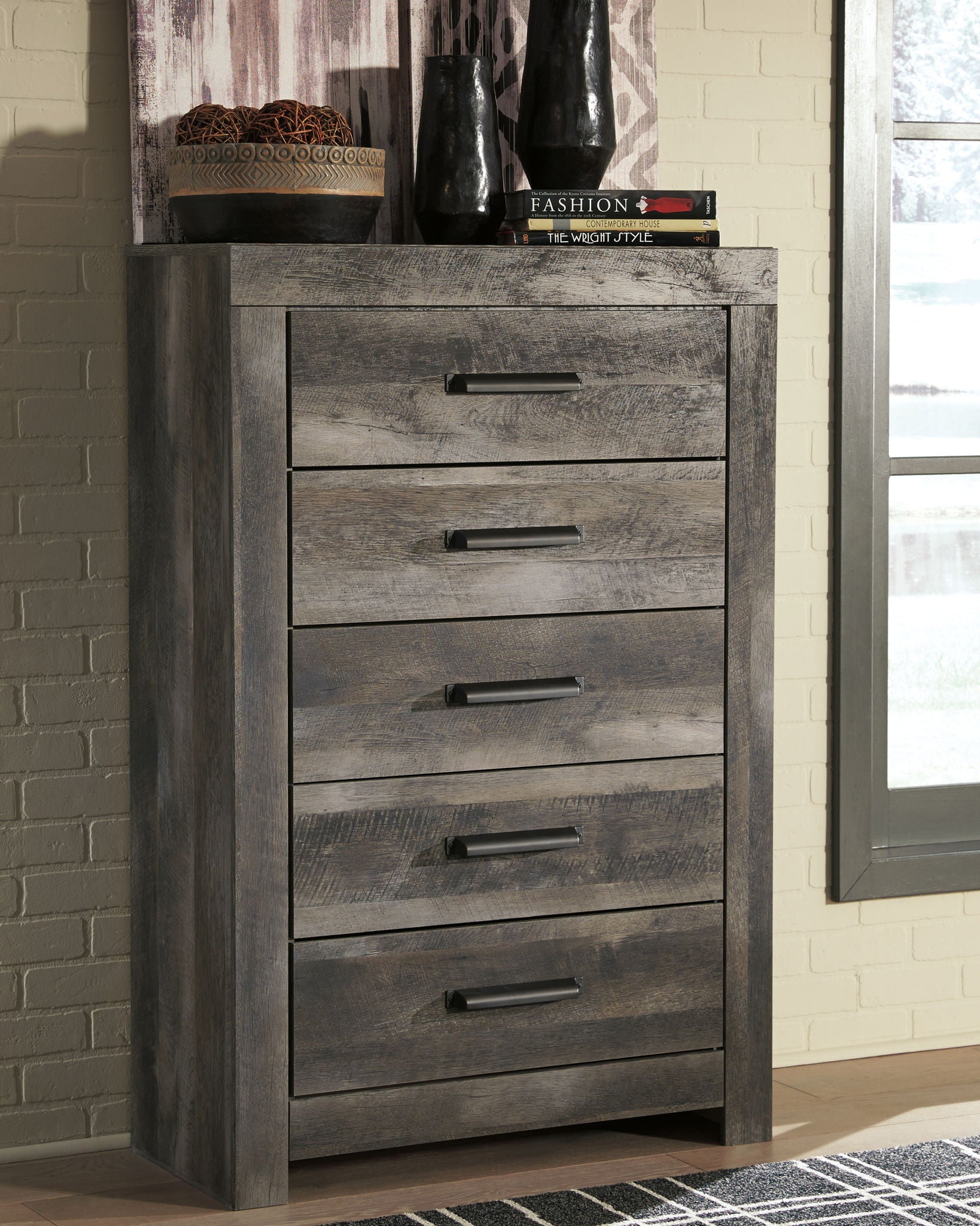 Gray chest of drawers with five drawers and black bar pulls