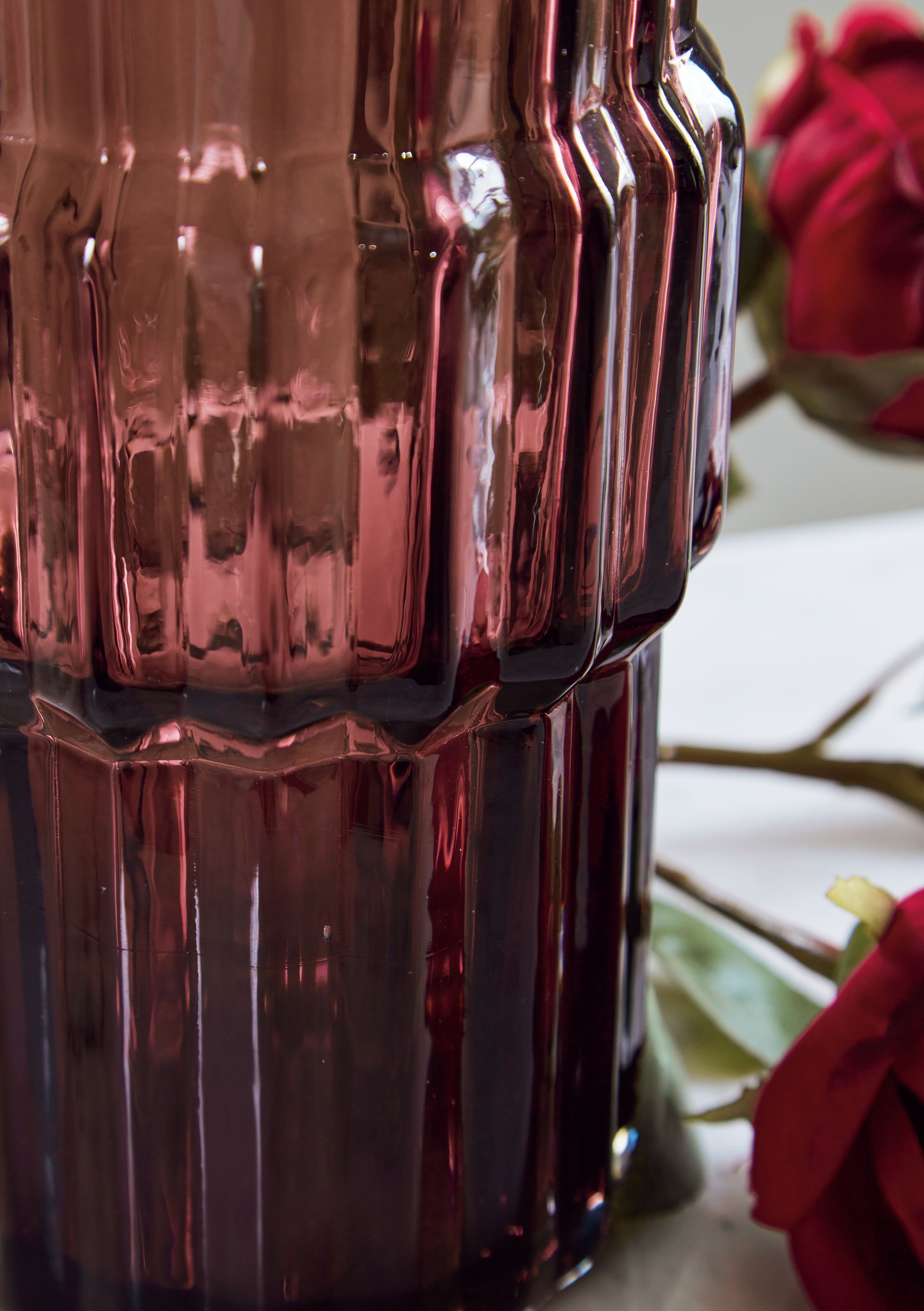 Purple ribbed glass vase with reflective facets and geometric panel ridges