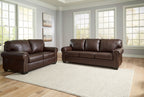 Dark brown upholstered sofa and loveseat set with rolled arms and nailhead trim