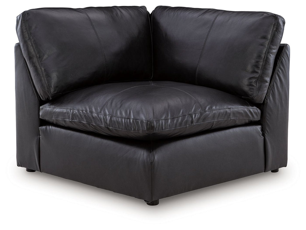 Black wedge sofa chair with padded arms, cushioned seat, and square legs