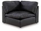 Black wedge sofa chair with padded arms, cushioned seat, and square legs