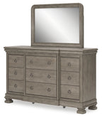 Gray dresser with tall rectangular mirror and multiple drawers with oval knobs