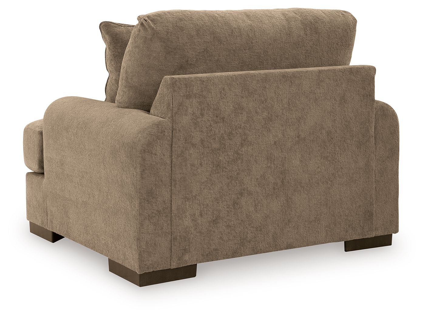 Armchair in light brown fabric with wide arms and dark wooden legs, viewed from side angle