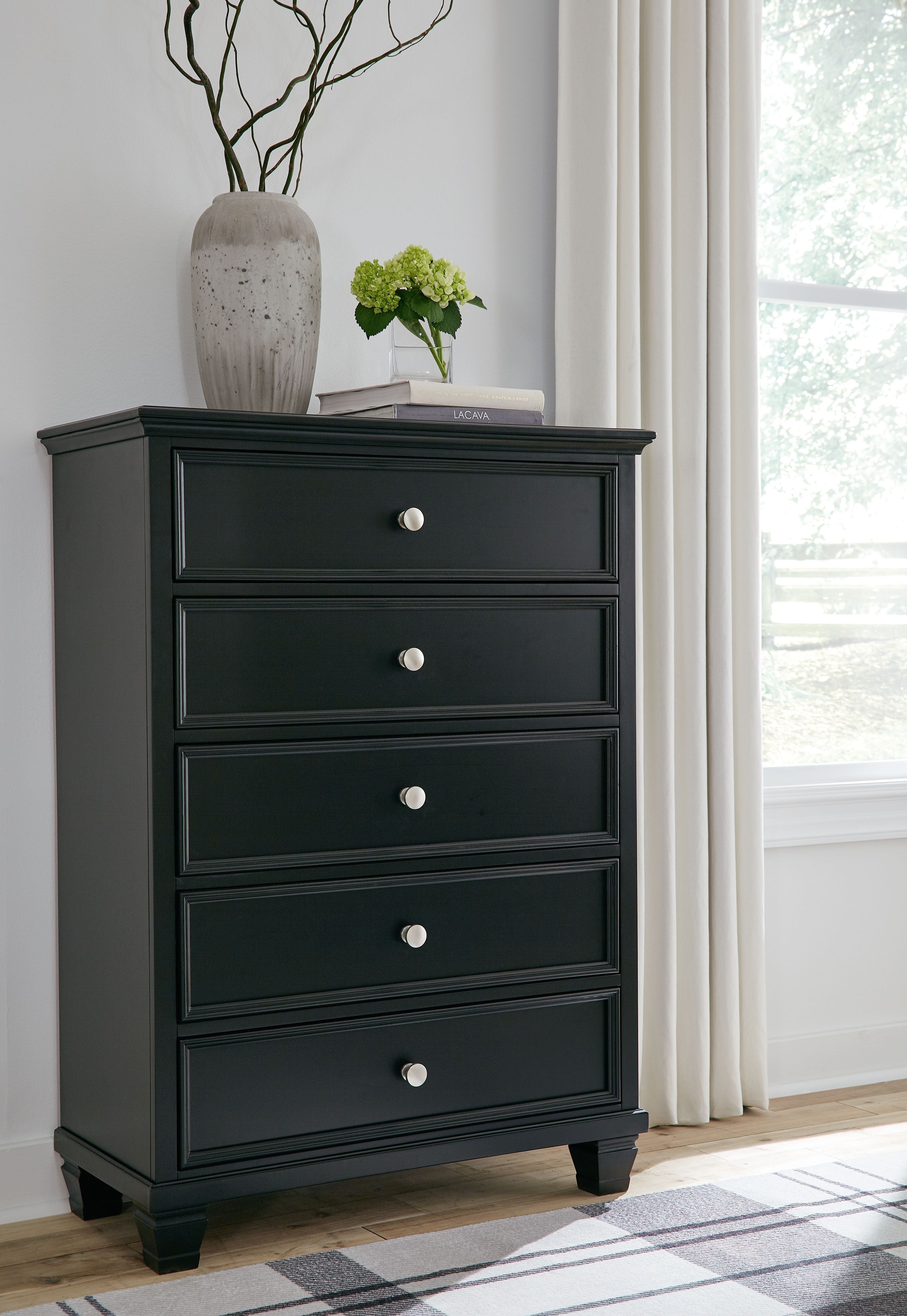 Dark five-drawer chest with round knobs and stacked drawer fronts