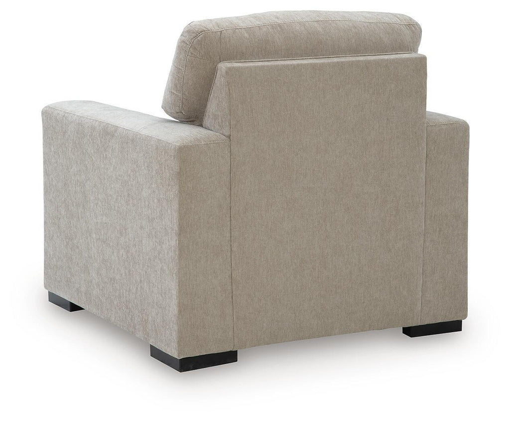 Light gray upholstered armchair rear view with padded headrest and armrests