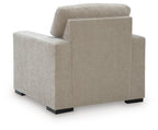 Light gray upholstered armchair rear view with padded headrest and armrests