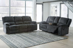 Dark gray reclining sofa and loveseat set with padded arms and tufted back