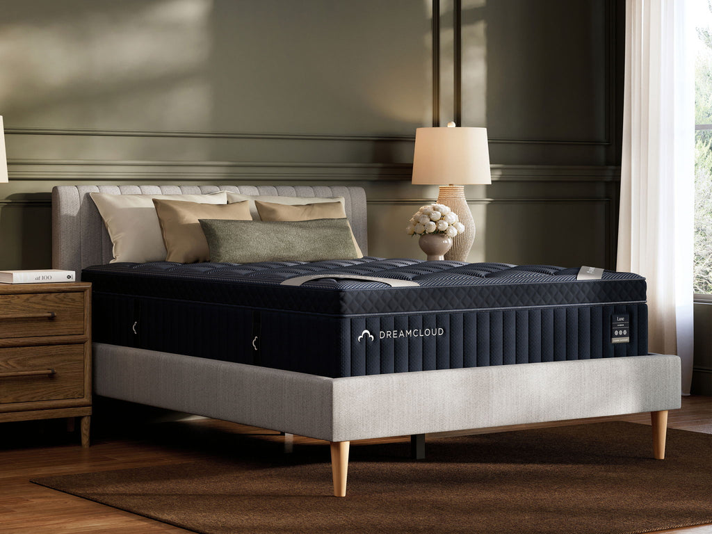 DreamCloud Luxe hybrid mattress on bed with blue quilted top and dark base