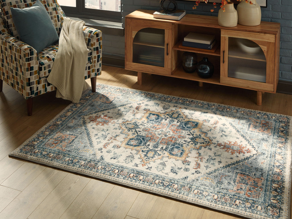 Wallney rug laid flat with cream field, blue ornamental center, distressed border