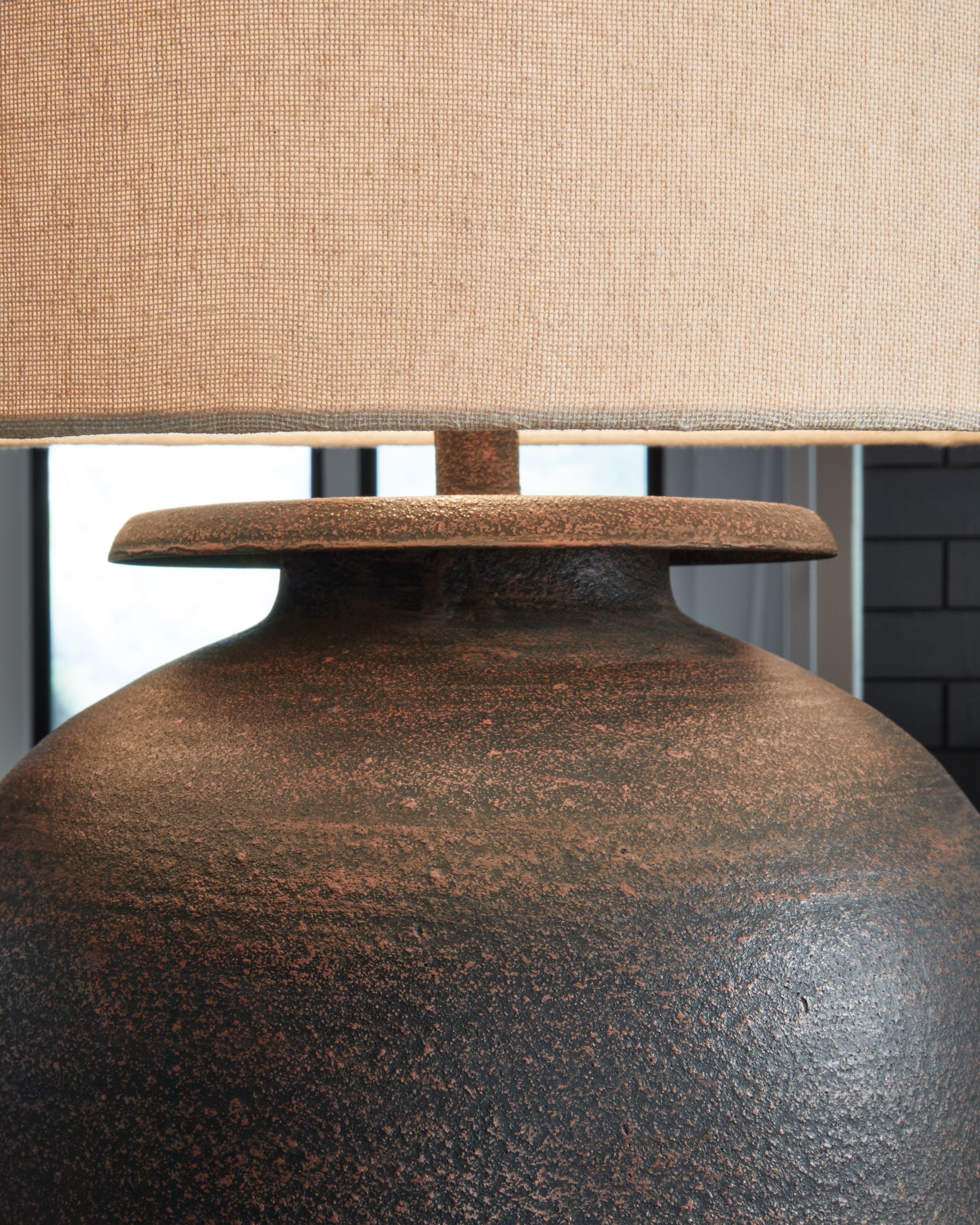 Antique brown metal lamp base with circular top and beige drum shade