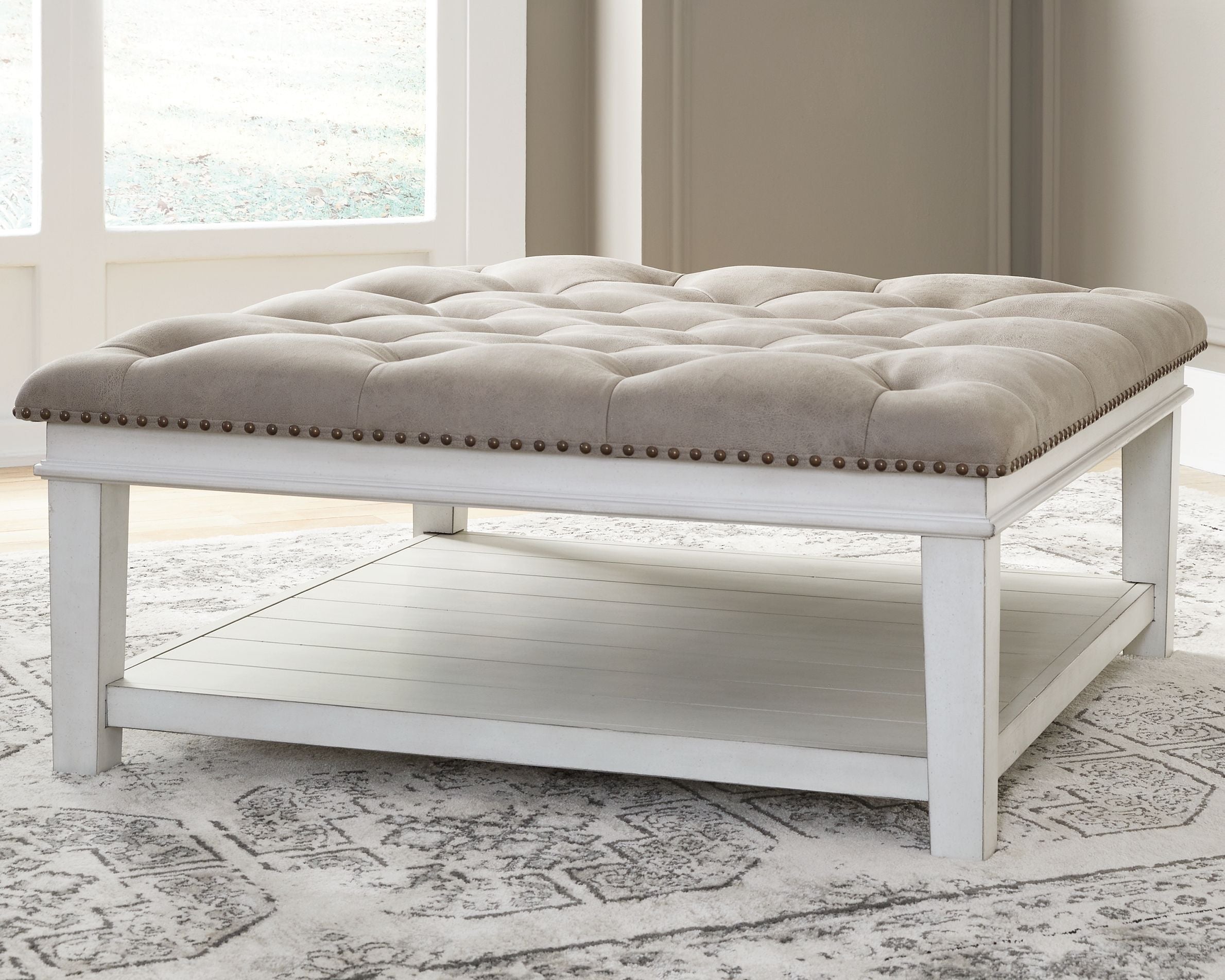 Tufted ottoman cocktail table, whitewash frame, nailhead trim, open shelf