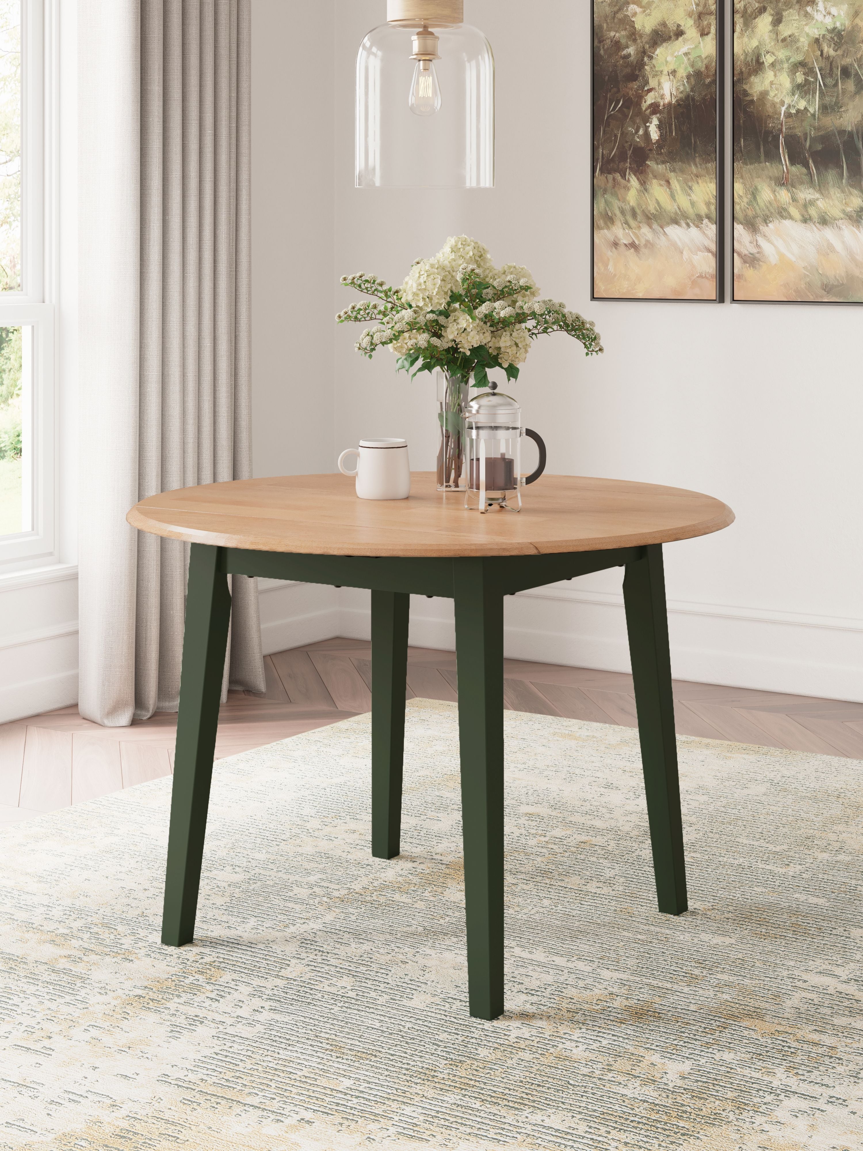 Round drop-leaf dining table with light wood top and green legs