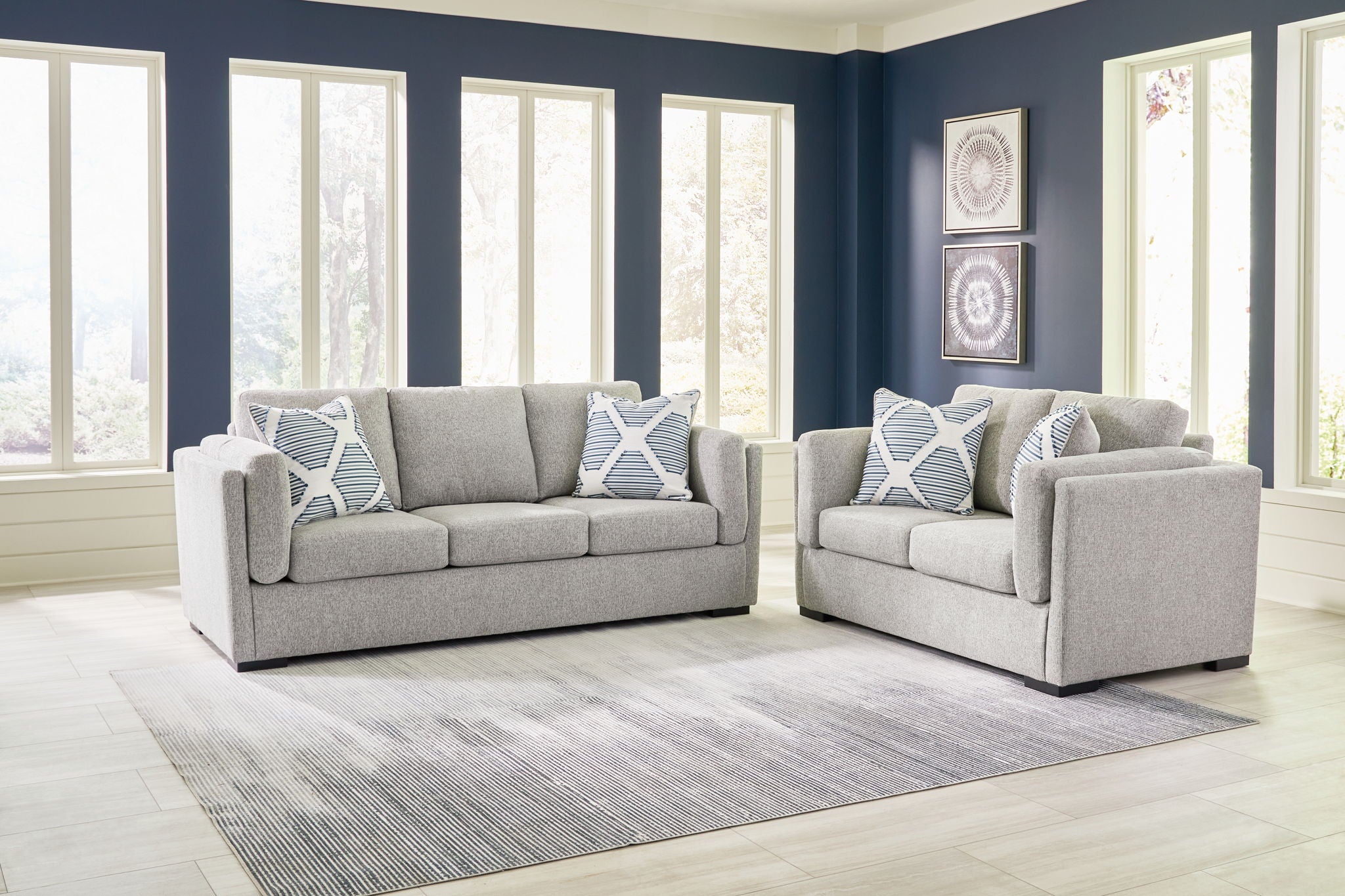 Light gray living room sofa set with two matching pieces and patterned throw pillows