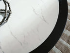 White marble-look table top with gray veining and black outer edge