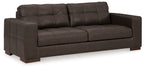Dark brown sofa with tufted cushions and padded arms, three-seat styling