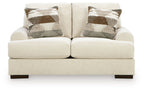 Cream loveseat sofa with two seat cushions and two patterned accent pillows, square arms
