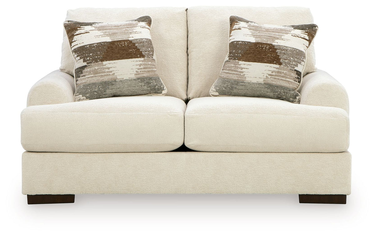 Beige loveseat with three patterned throw pillows and two solid cushions