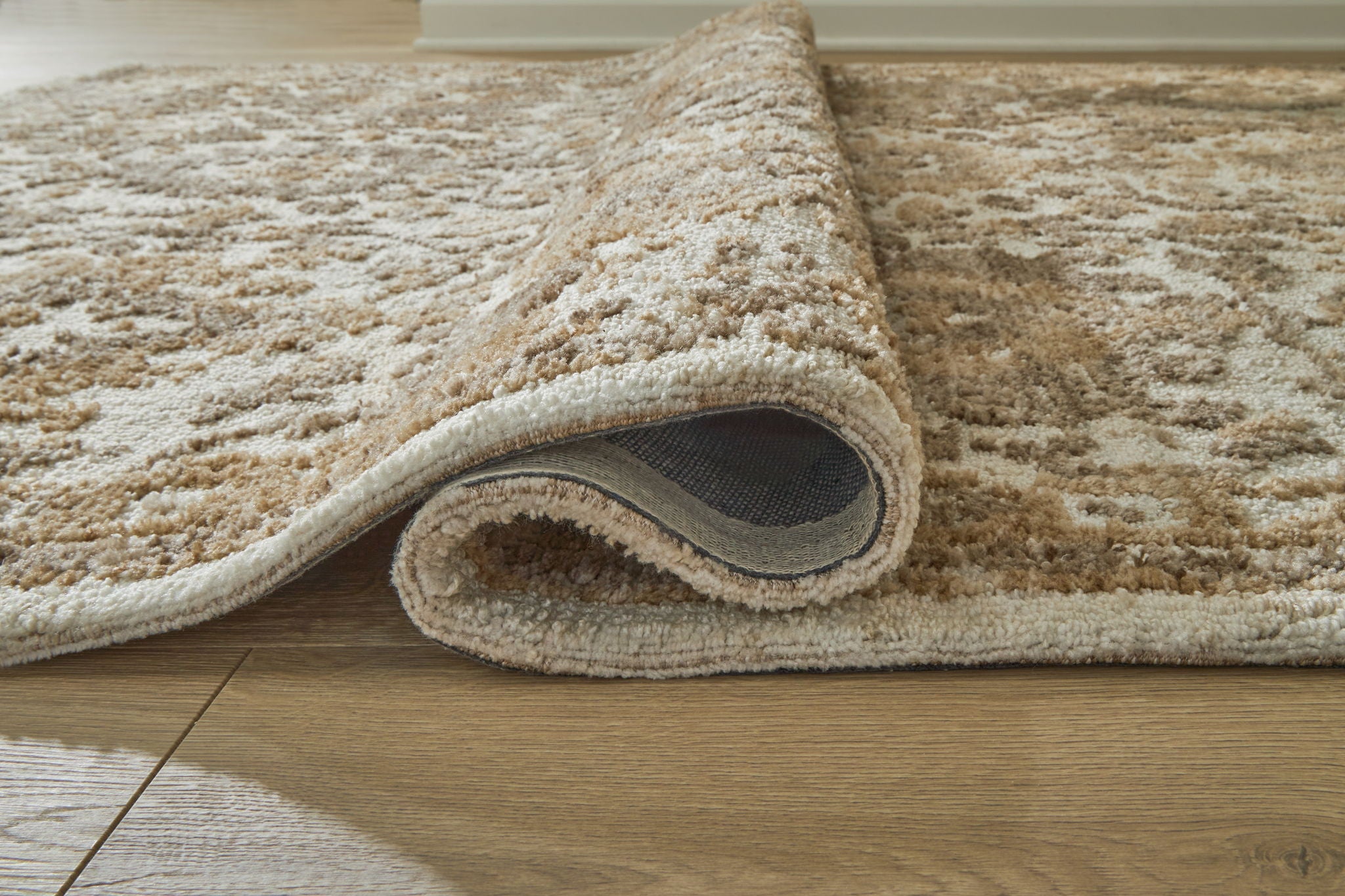 Light brown patterned area rug with cut-pile texture and rounded edge