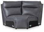 Dark gray sectional wedge with cushioned backrest, curved arms, and block base