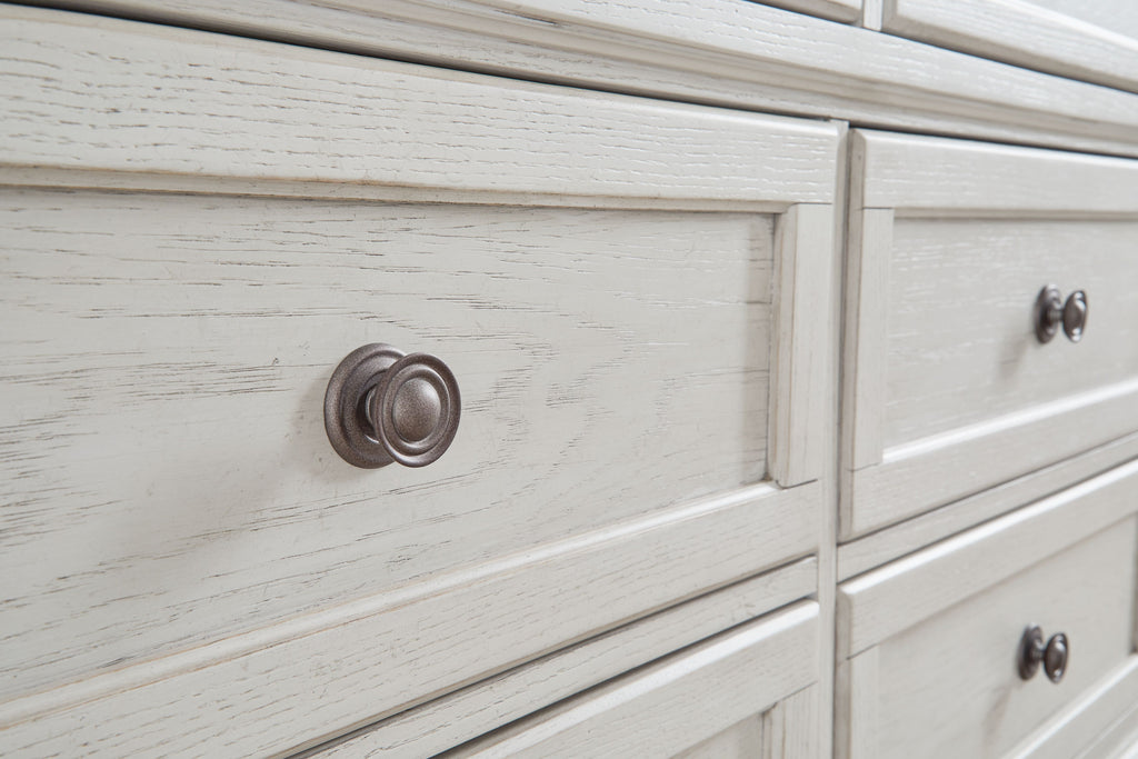 Antique white dresser drawer fronts with round metal knobs, distressed wood grain