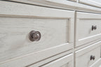 Antique white dresser drawer fronts with round metal knobs, distressed wood grain