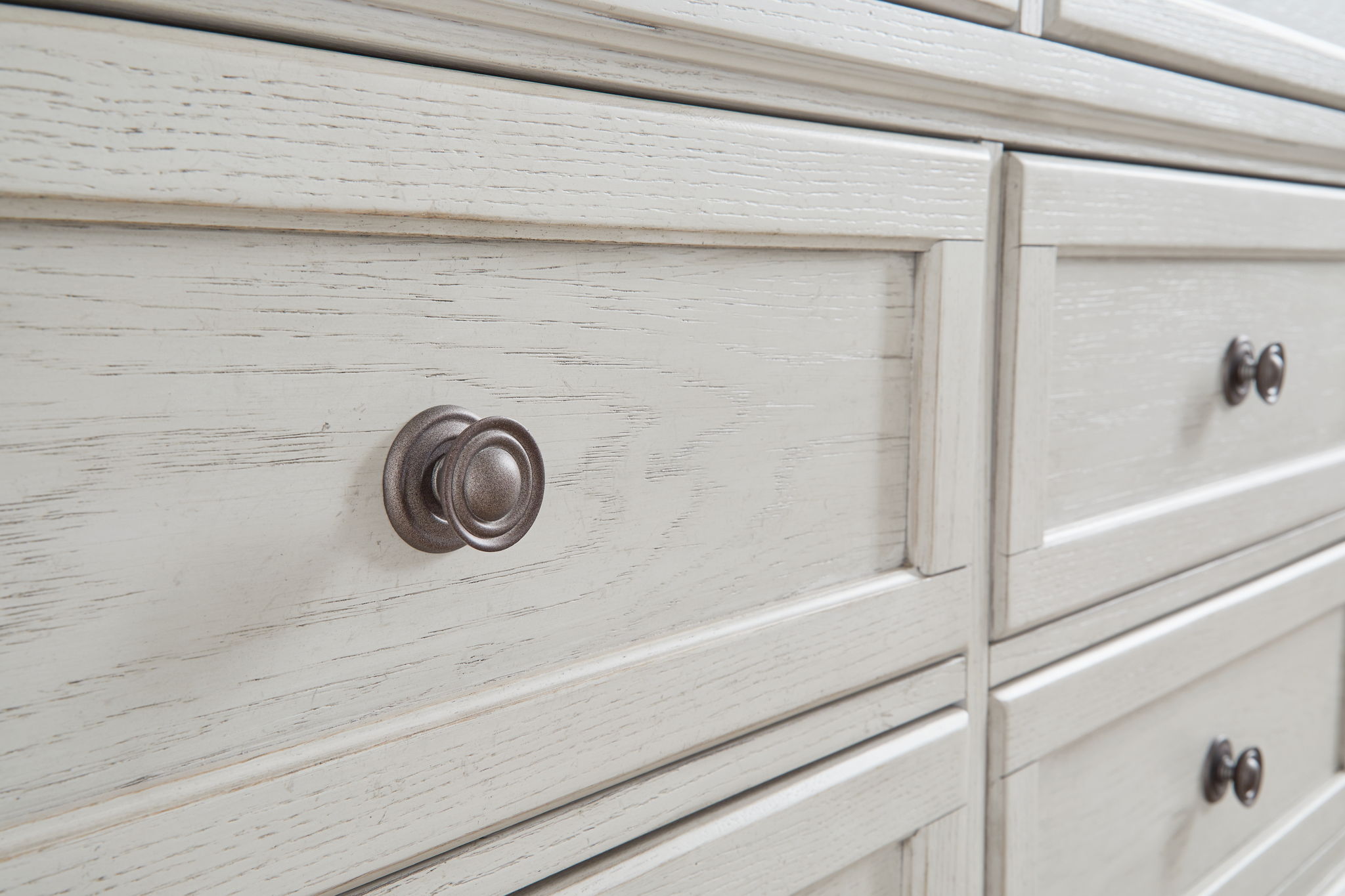 Antique white dresser drawer with round metal knob and wood grain texture