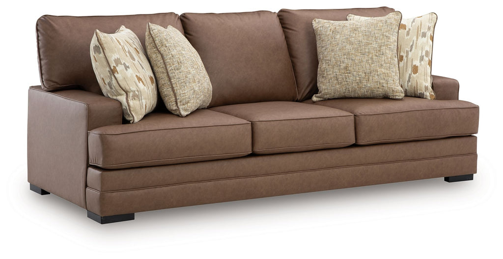 Caramel brown sofa with square arms, three seat cushions, and patterned throw pillows