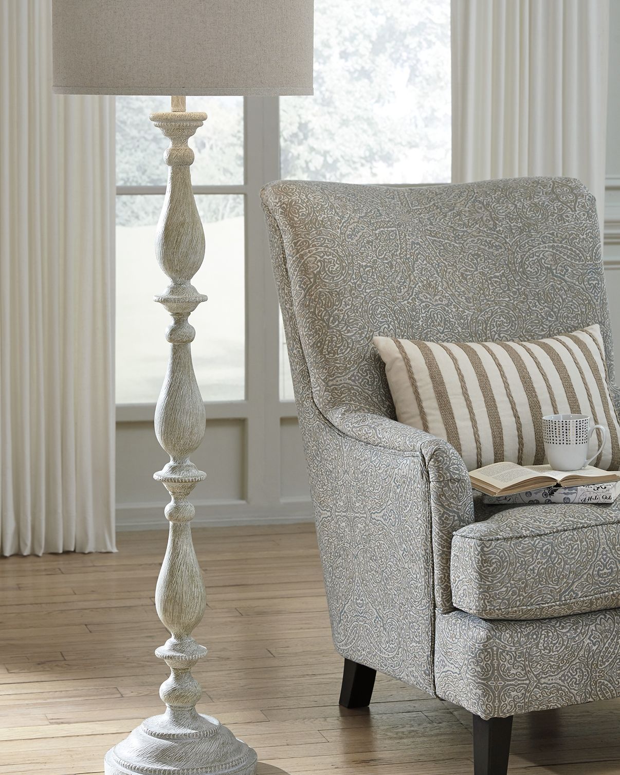 Whitewash poly floor lamp with beige fabric drum shade and turned pedestal base