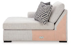 Stone gray chaise corner seat with patterned lumbar pillow and wood-tone base panel