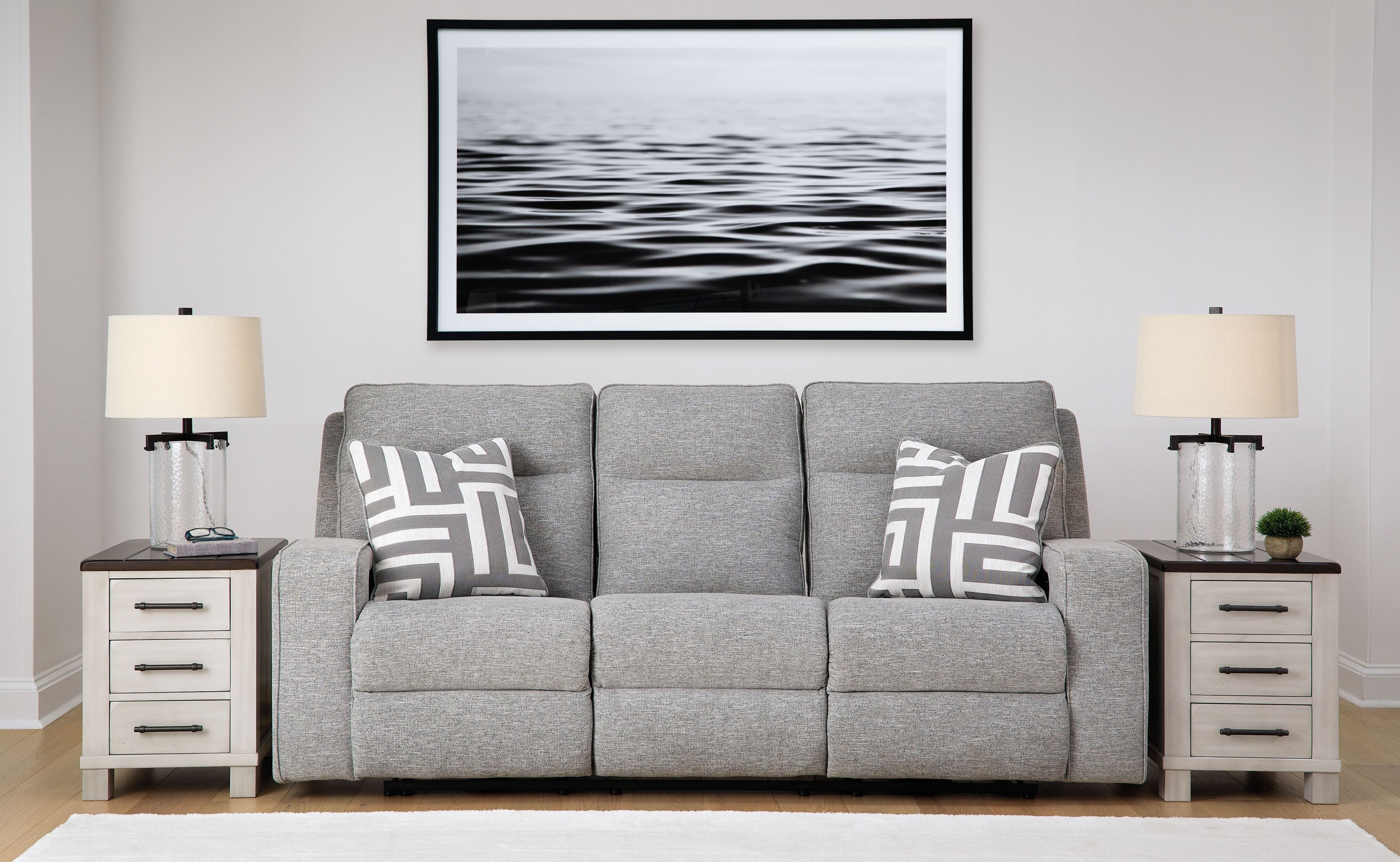 Pewter power reclining sofa with three seat sections, gray upholstery, and patterned throw pillows