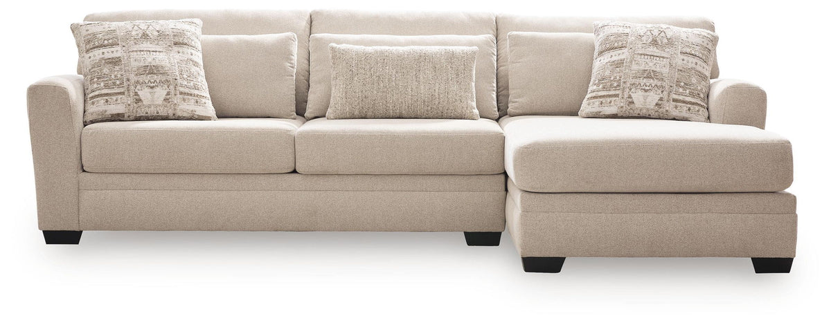 Light beige sectional sofa with chaise, three seat sections, patterned accent pillows