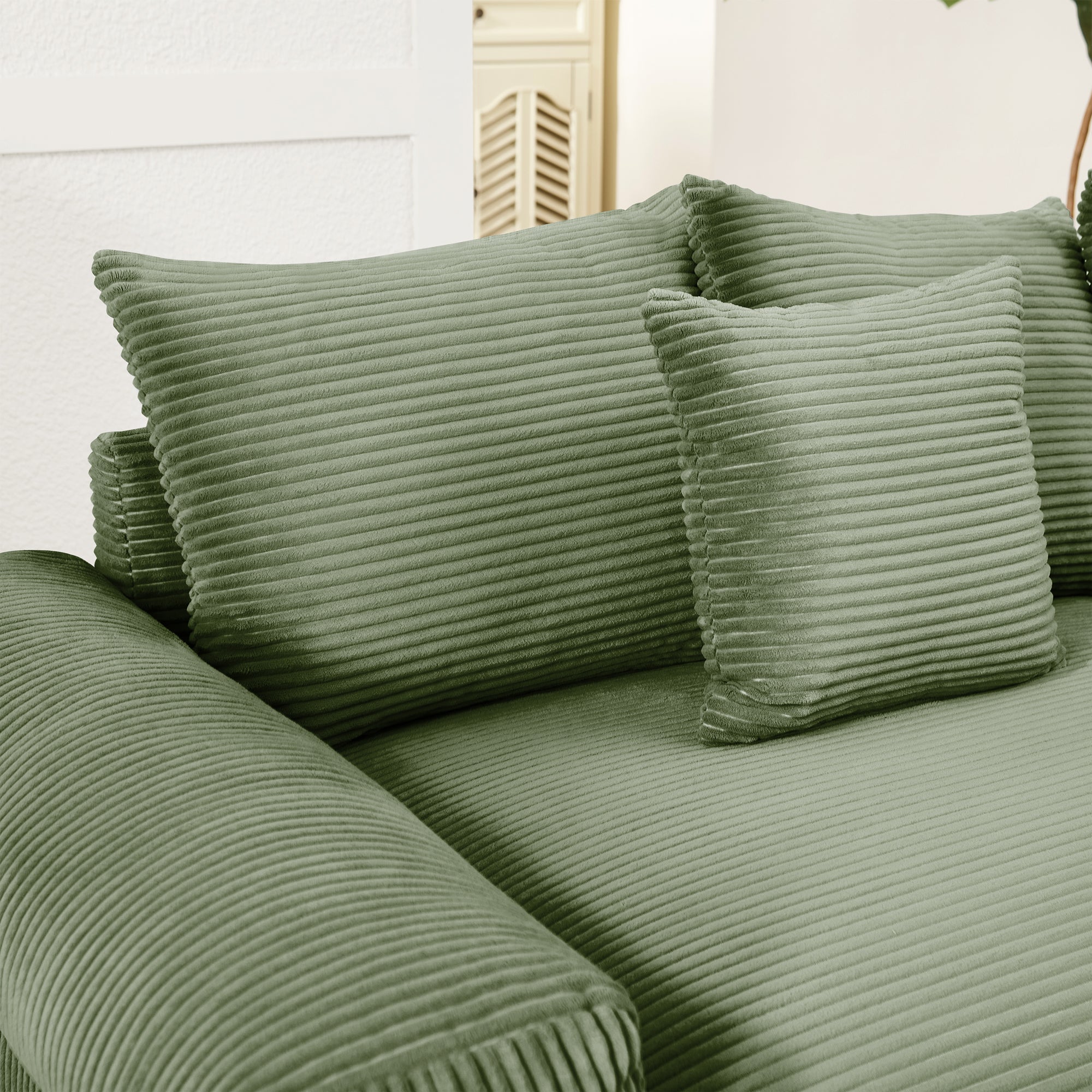 Green corduroy sectional sofa with back cushions and rolled arm