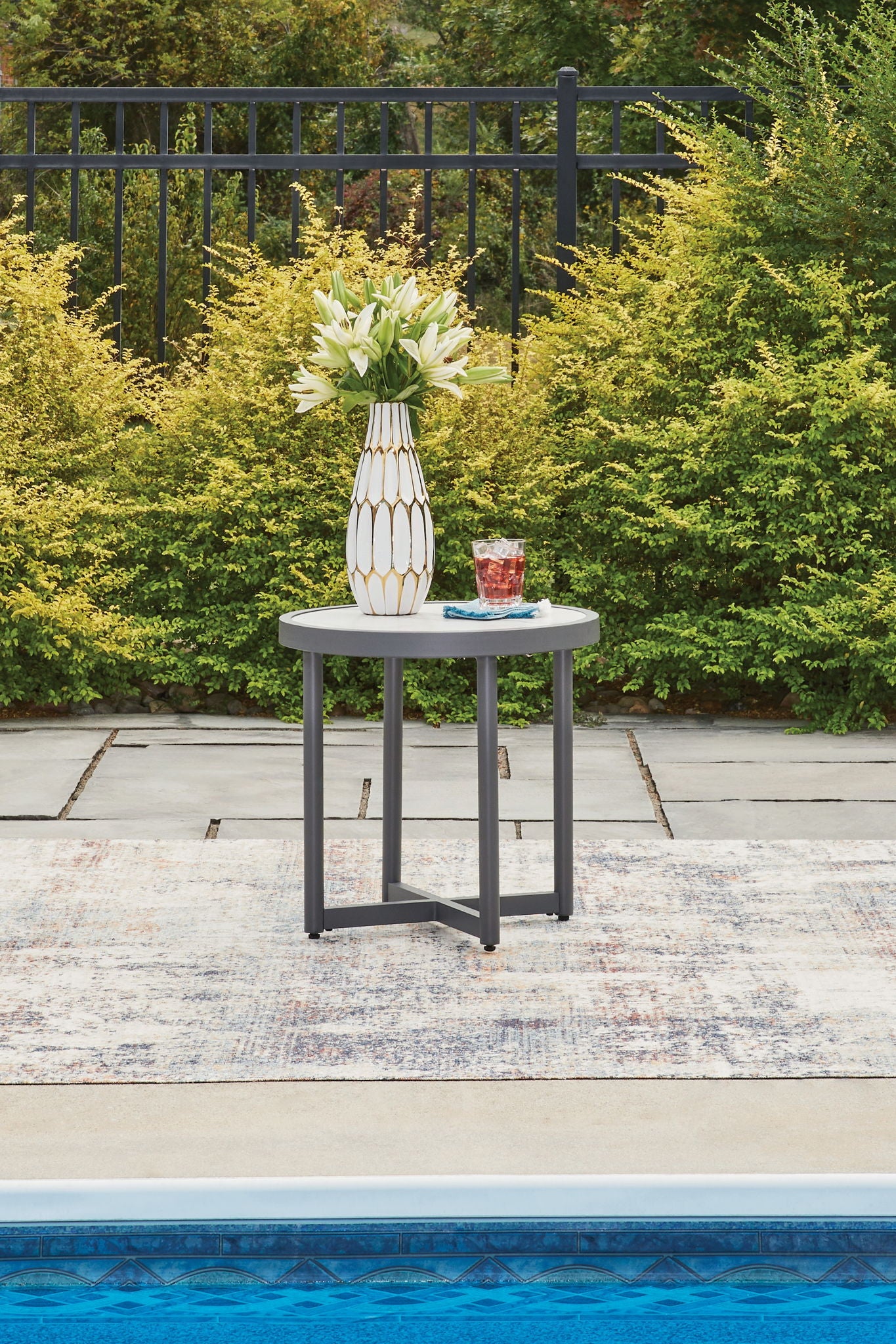 Gray round patio coffee table with marble-look top and open base frame