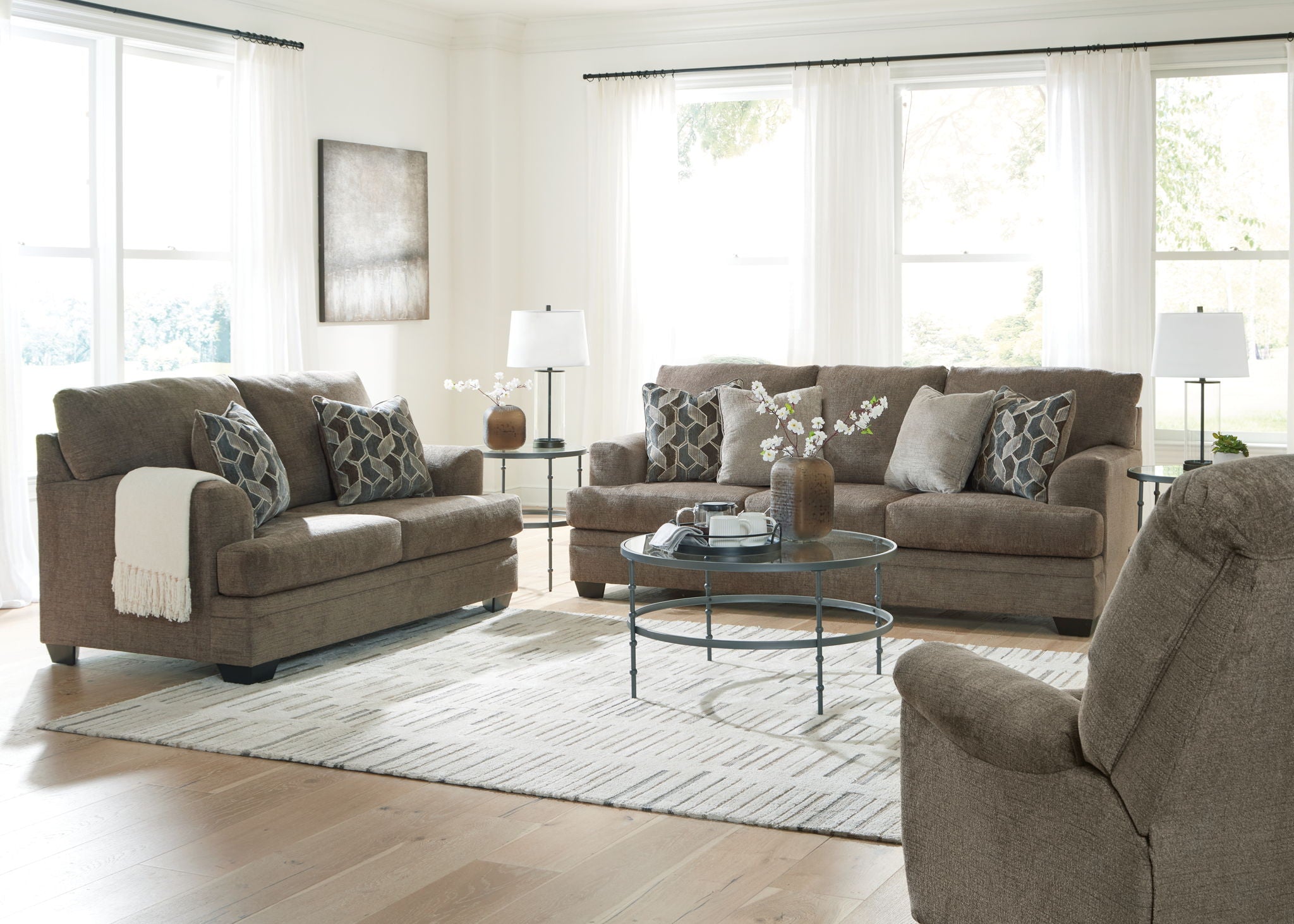 Taupe fabric living room sofa set with chaise, ottoman, and patterned throw pillows