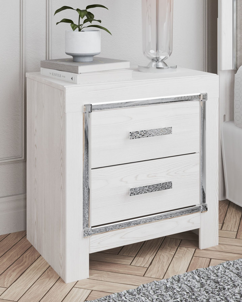 White two-drawer night stand with chrome handles; top holds a white planter