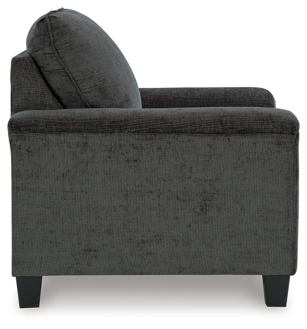 Dark gray upholstered armchair side view with wide armrests and tapered legs
