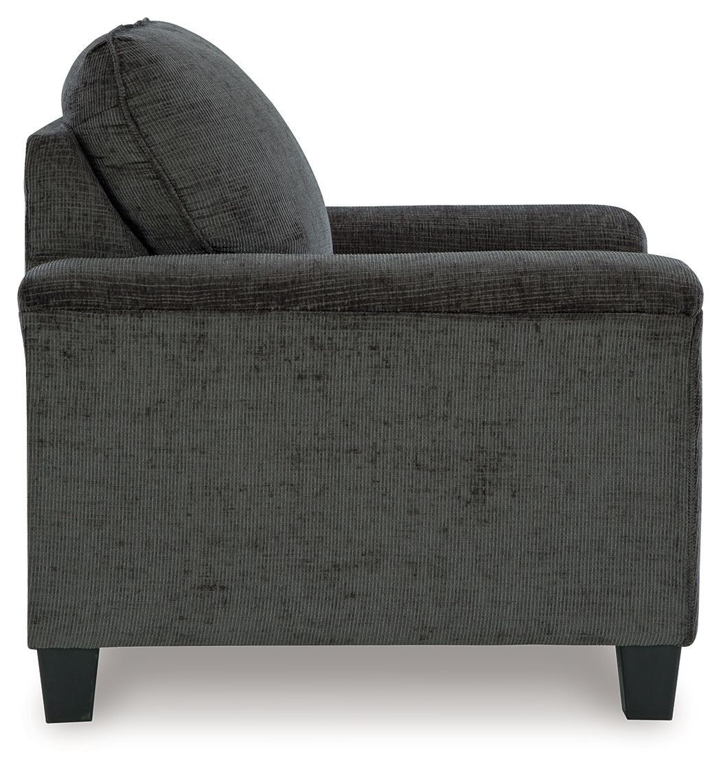 Dark gray upholstered armchair side view with wide armrests and tapered legs