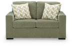 Olive green upholstered loveseat with two patterned accent pillows and padded arms