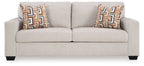 Light beige sofa with two geometric throw pillows, two-seat back and low legs