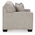 Light beige loveseat with square arms and one patterned throw pillow