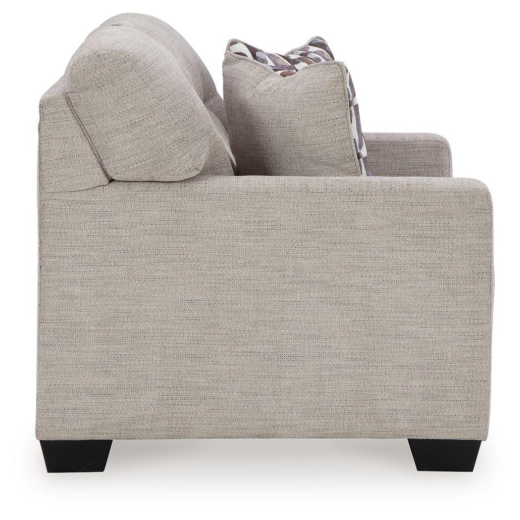 Light beige loveseat with square arms and one patterned throw pillow