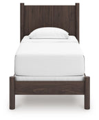 Dark brown panel bed with white upholstered mattress and curved headboard