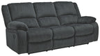 Draycoll reclining sofa in slate with rounded armrest, cushioned chaise seat, tufted back