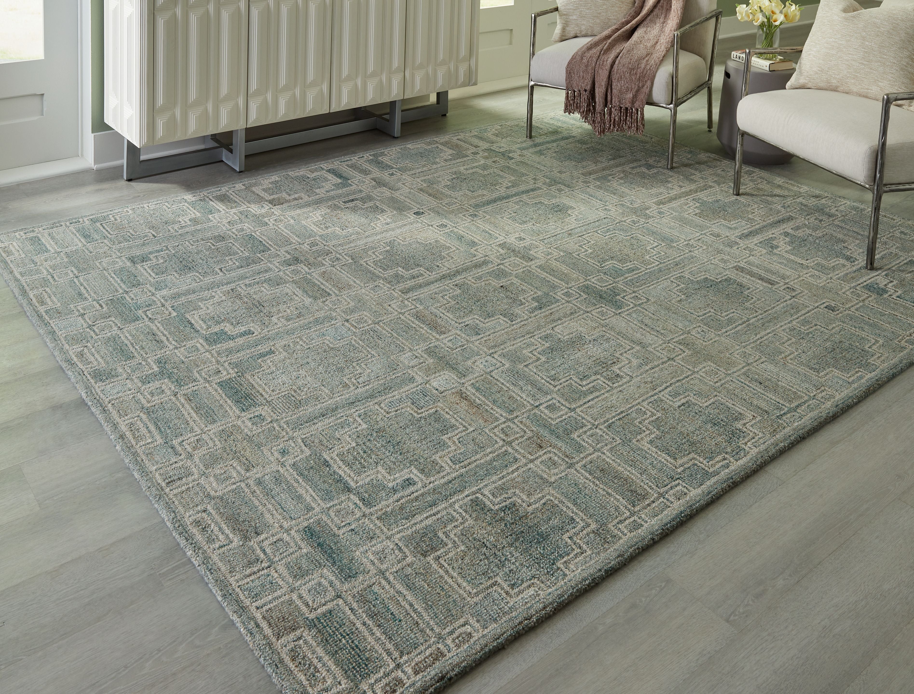 Green geometric area rug with repeating square motifs, flat-woven look